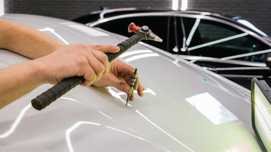 pracownik naprawiający karoserię samochodu